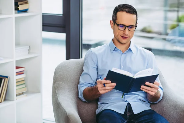 ciddi iş adamı cheking notlar ofis koltuk üzerinde otururken defter