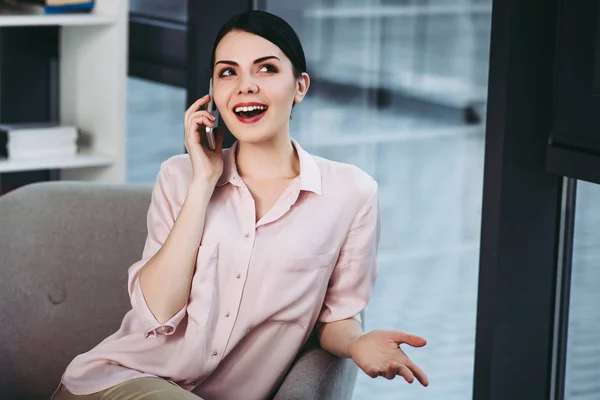 Mujer Sonriente Hablando Teléfono Inteligente Mientras Está Sentada Sillón —  Fotos de Stock