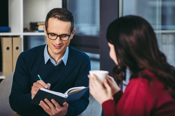 Sonriente Hombre Adulto Medio Tomando Notas Cuaderno Mientras Que Mujer —  Fotos de Stock