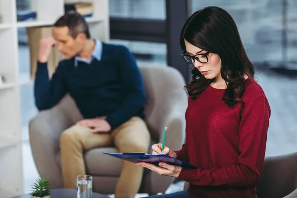 Vrouwelijke Psycholoog Maken Van Aantekeningen Het Document Klembord Met Depressieve — Stockfoto