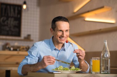 Öğle yemeği için salata yemek kafede masada oturan işadamı