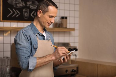 kafede çalışırken not alma garson yan görünüm