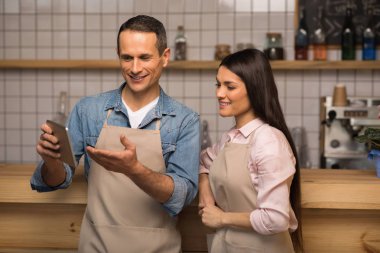 kafe sahibi bir şey dijital tablet kafede garson için gösterilen gülümseyen