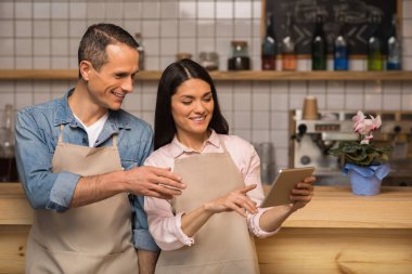Çift dijital tablet kullanma ve kahve dükkanında konuşurken kafe sahipleri