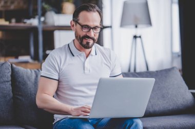 sakallı adam üstünde laptop evde çalışma gözlüklü portresi