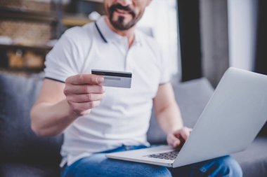 adam online kredi kartı ile alışveriş ve dizüstü evde kullanarak resim kırpılmış