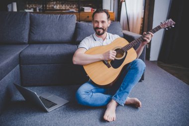 sakallı adam evde katta oturan gitar çalmak