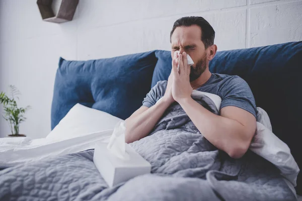 Mid Adult Man Sneezing Napkin Sitting Bed Home — Stock Photo, Image