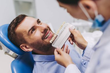 Diş implantları klinikte seçme dişçi koltuğu gülümseyen hastada portresi