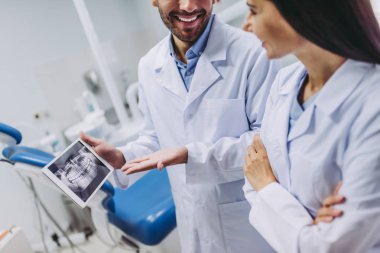 x-ışını modern diş kliniği ile dijital tablet ekranına bakarak doktorlar gülümseyen