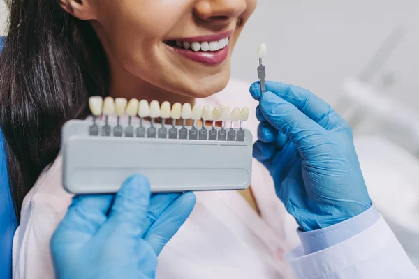 Przycięte Ujęcie Lekarza Pacjenta Wybierającego Implanty Zębów Nowoczesnej Klinice Stomatologicznej — Zdjęcie stockowe