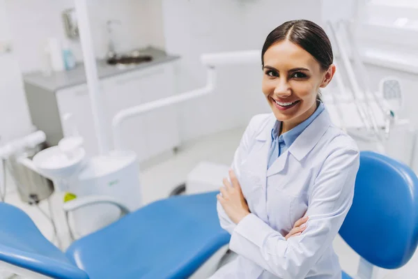 kadın dişçi ith gülümseyen havai görünümü diş kliniği kamerada bakarak elleri geçti