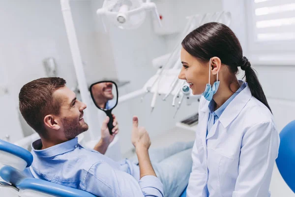 Paziente Maschio Sorridente Che Guarda Allo Specchio Masticando Denti Dopo — Foto Stock