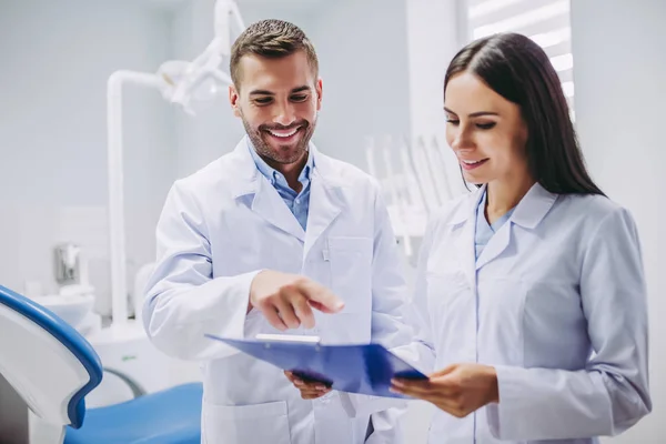 Retrato Dentista Sorridente Assistente Olhando Para Prancheta Clínica Odontológica Moderna — Fotografia de Stock