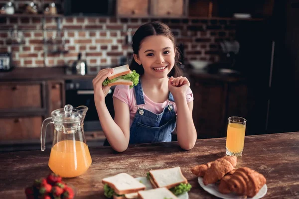 Retrato Chica Caucásica Sonriente Sosteniendo Sándwich Mirando Cámara Cocina — Foto de Stock