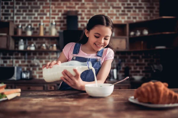 Chica Sonriente Vertiendo Leche Tazón Hojuelas Maíz Para Desayuno Cocina — Foto de Stock