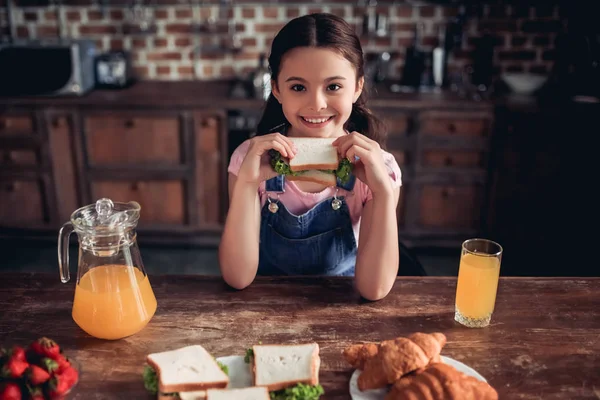 Feliz Chica Sonriente Comiendo Sándwich Para Desayuno Mirando Cámara Cocina — Foto de Stock