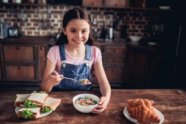 Chica Comiendo Copos Maíz Colores Con Leche Mirando Cámara Cocina — Foto de Stock