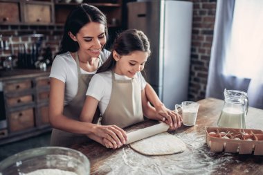 Anne ve kızı mutfak bir hamur merdane ile yayıyoruz gülümseyen