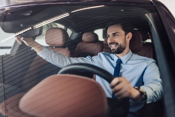 Vista Frontal Del Hombre Negocios Sonriente Ajustando Espejo Retrovisor Coche — Foto de Stock