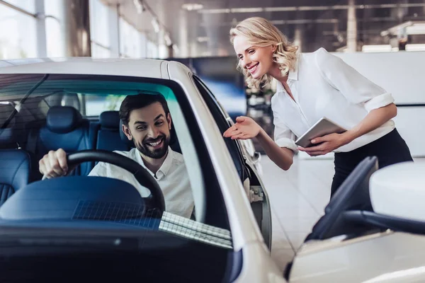 Portret Van Lachende Verkoopster Tonen Aan Mannelijke Klant Nieuwe Auto — Stockfoto