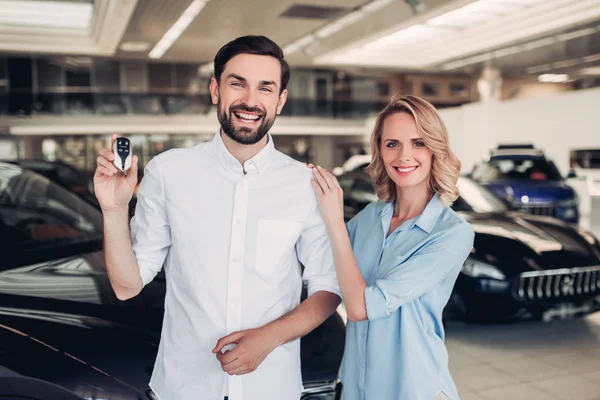 Retrato Feliz Pareja Sosteniendo Llaves Coche Nuevo Salón Concesionarios — Foto de Stock