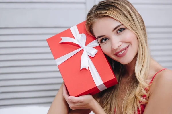 バレンタインの日の概念を若い女性持株赤いギフト ボックスを笑顔の肖像画 — ストック写真
