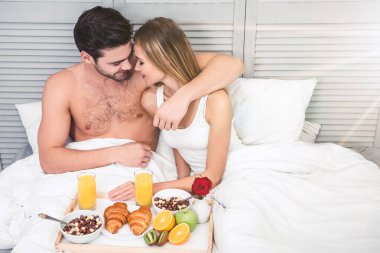 Genç çift sarılma havai görünümü birlikte, sabah yatakta kahvaltı