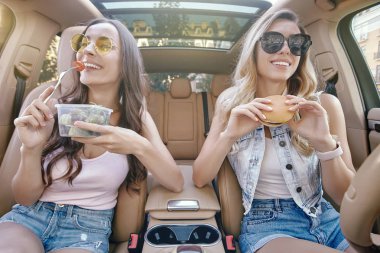iki çekici kadın arabada otururken payet ile taze meyve suyu içme