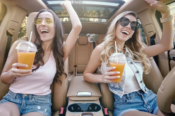 Twee Aantrekkelijke Vrouwen Drinken Van Vers Sap Met Rietjes Zittend — Stockfoto