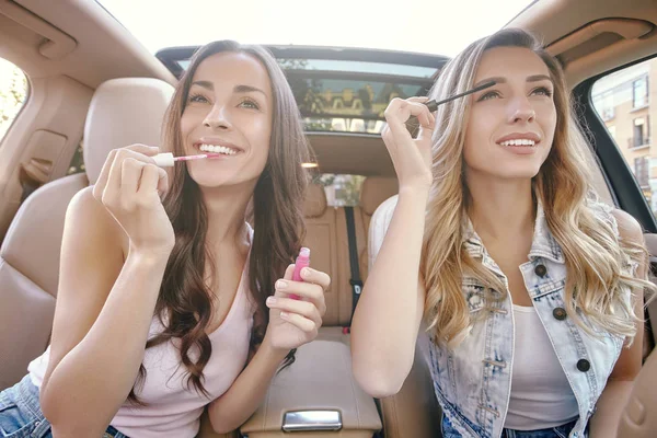 attractive young women doing make up in the luxury car