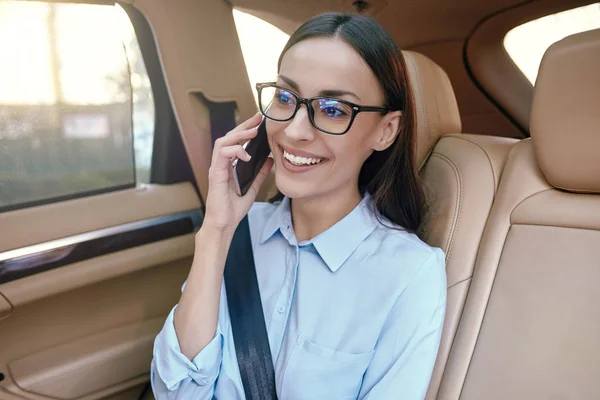 微笑的女商人在智能手机上谈论在车上 — 图库照片