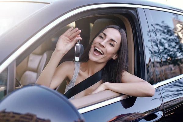 Hymyilevä Nuori Nainen Jolla Avaimet Istuu Uudessa Autossa — kuvapankkivalokuva