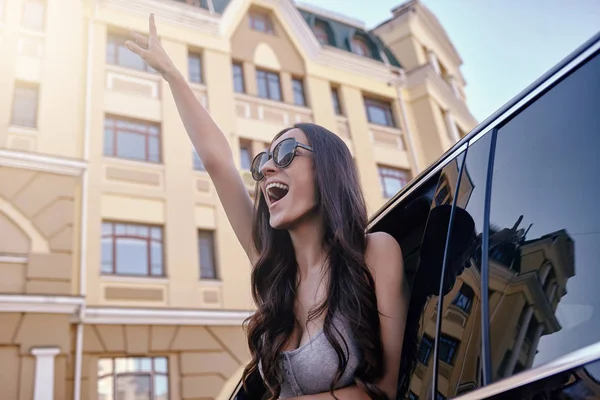 Rire Jeune Femme Levant Main Regardant Par Fenêtre Voiture — Photo