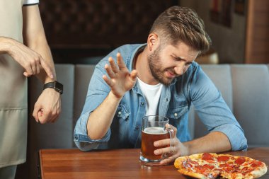 Kafe şu andaki sarhoş müşteri için üzerinde kapanış saati gösteren garson