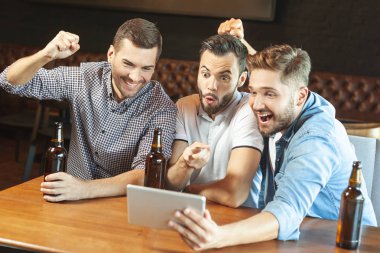 bira içip spor oyun kafede dijital tablet izlerken duygusal hayranları