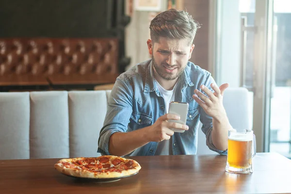 Hombre Descontento Mirando Teléfono Inteligente Mientras Está Sentado Cafetería — Foto de Stock