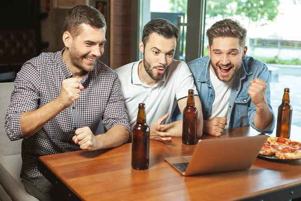 Три Болельщика Пьют Пиво Смотрят Спортивную Игру Ноутбуке Кафе — стоковое фото