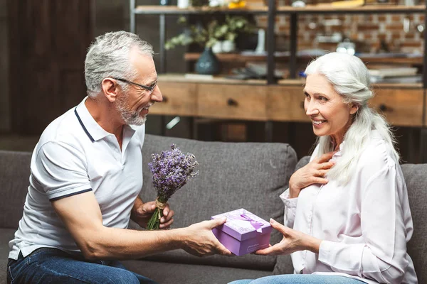 cheerful woman taking present from man for anniversary