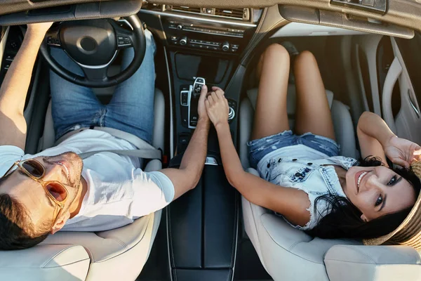 oturma cabriolet sırasında elele ve kameraya bakarak Genç çift havai görünümü