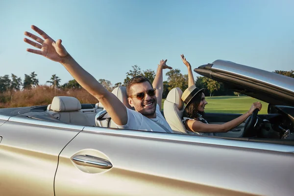 Smilinbg Casal Dirigindo Cabriolet Levantando Mãos Juntos — Fotografia de Stock