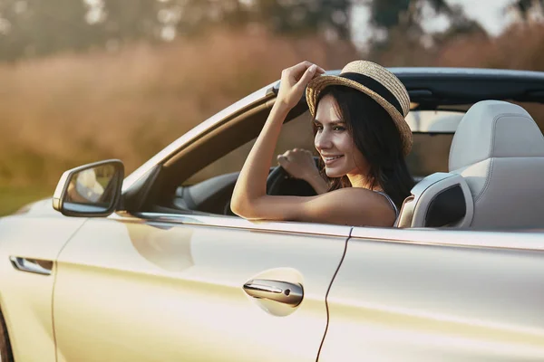 Attractive Young Brunette Driving Cabrio Holding Hand Hat Looking Away — Stock Photo, Image