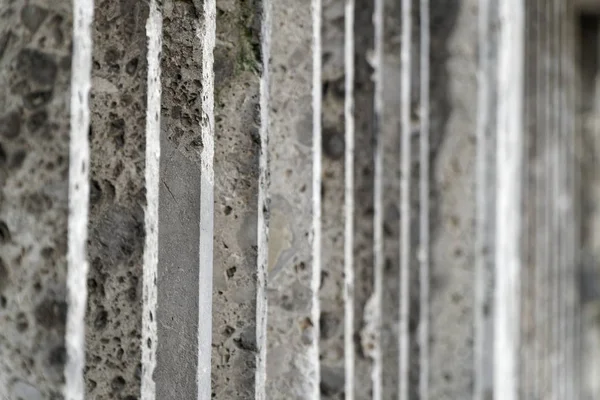 Steinzaun mit parallelen Betonpfählen und altem grünen Moos — Stockfoto