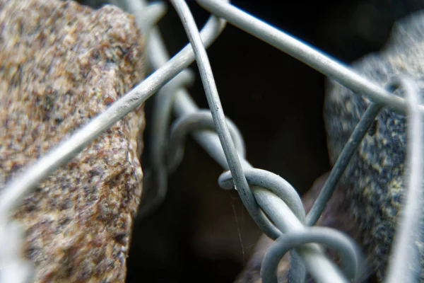 Alambre de aluminio retorcido en el objeto de piedra, fondo macro —  Fotos de Stock