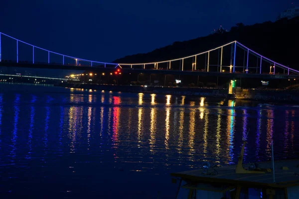 Luces parpadeantes en el puente nocturno, brillo en el reflejo del agua —  Fotos de Stock