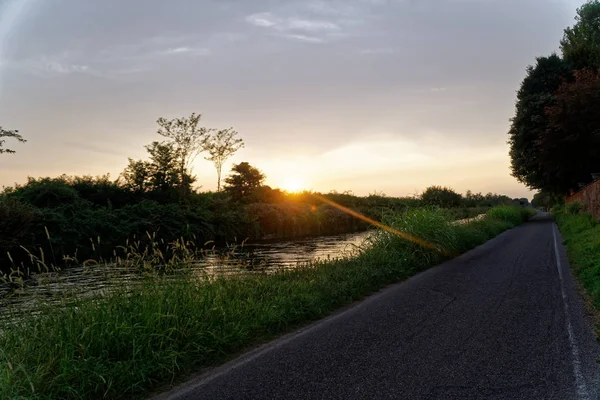 Pohled na řeku, západ slunce nad horami, vodní plochy s odrazem. — Stock fotografie