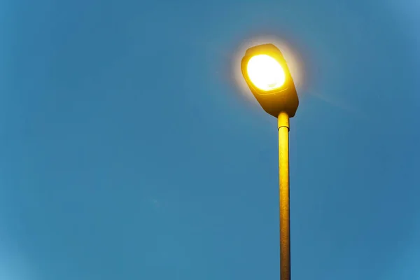 Lâmpada de rua ilumina no caminho vazio à noite — Fotografia de Stock