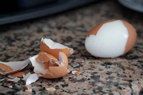 Жесткий вареные яйца с оболочкой рядом на гранитной доске (селективный фокус, фокус на передней части оболочки на первом яйце ). — стоковое фото