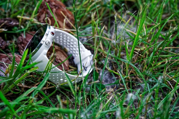 Sport watch for running white color on the ground in the grass. Fitness watch for tracking daily activity and strength training.