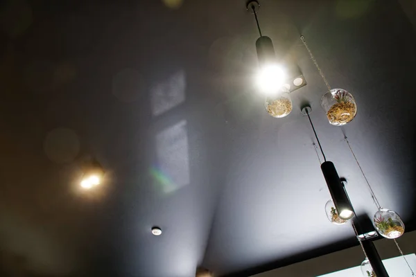 Dekorative Lichtgestaltung, Café-Innenausstattung, Lampe mit Glühbirne, die im Café hängt. dekorativer industrieller Loft-Stil im Restaurant - Panoramaaufnahme. lizenzfreie Stockfotos